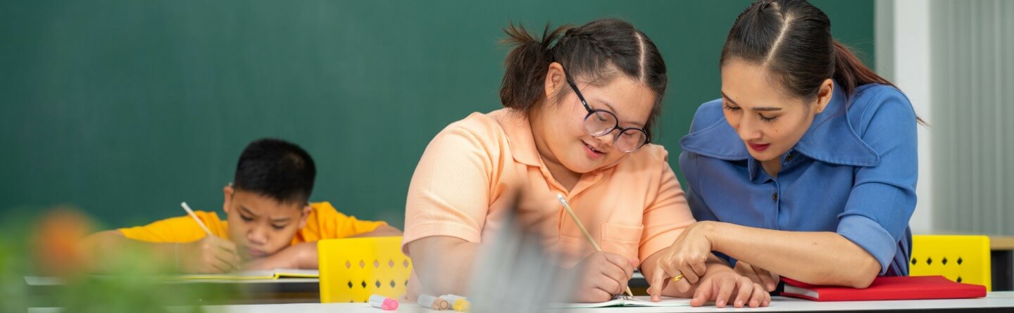 Headerbild: Schulbegleiterin unterstützt Schüler*innen bei den Hausaufgaben