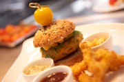 Foto eines Tellers mit einem Burger mit Soße und frittierten Gemüsesticks